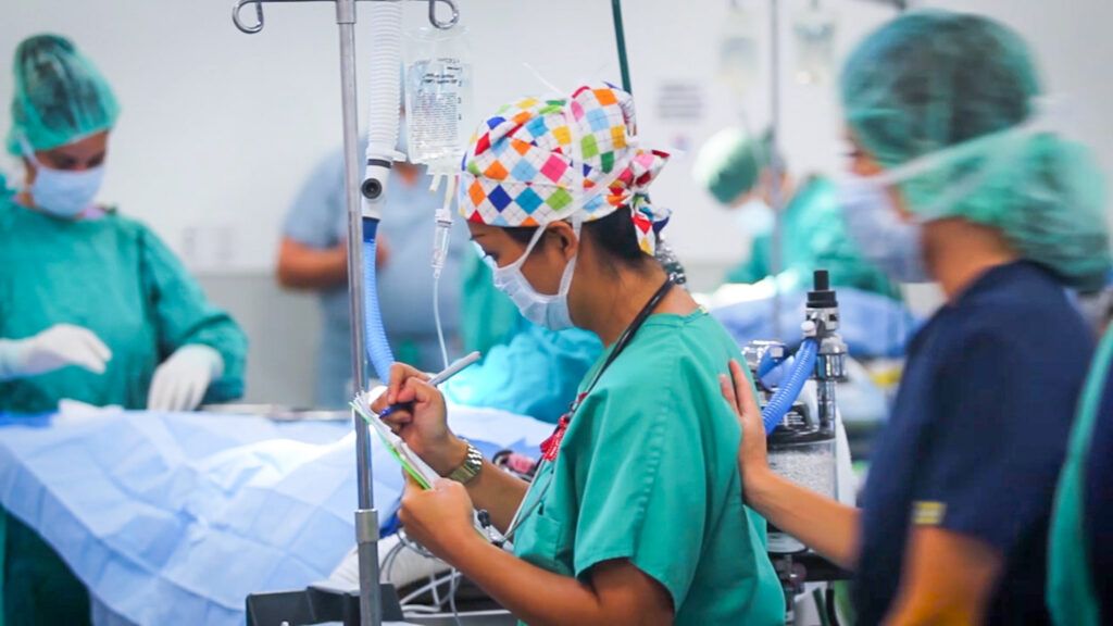 SGU student in scrubs preparing for a procedure