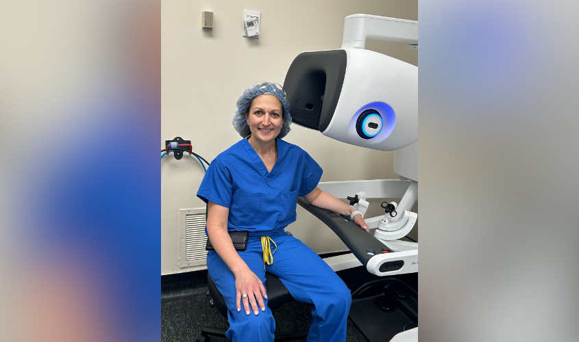 Dr. Pakula sitting with the DaVinci 5 robotic surgery device