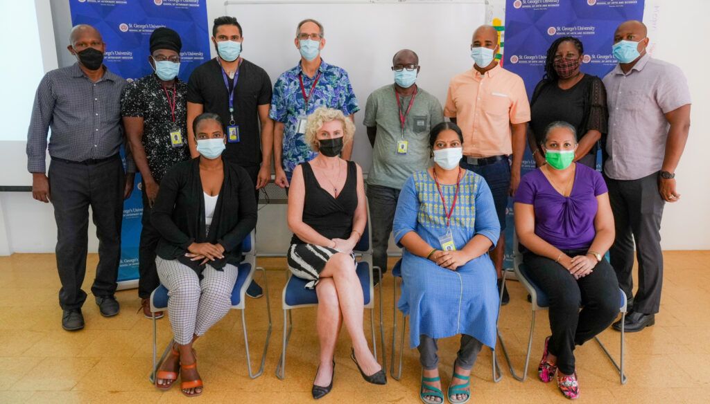 Team photo of SGU administrators and professors in a professional setting, adhering to health and safety protocols with masks.