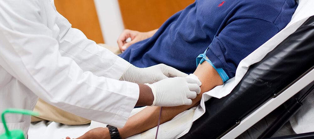 Phlebotomist prepping patient