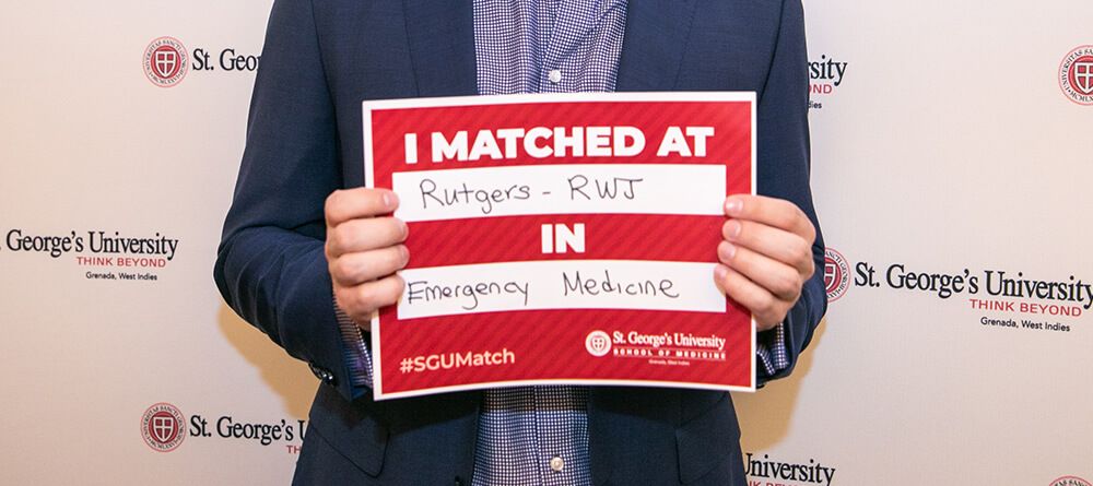 Student holding match sign