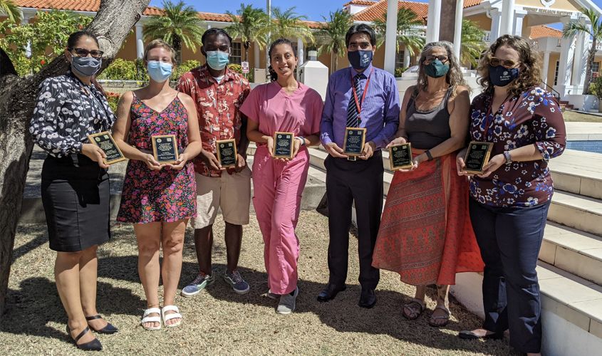 Students and faculty gathered around a poster presentation at St. George's University Research Day News
