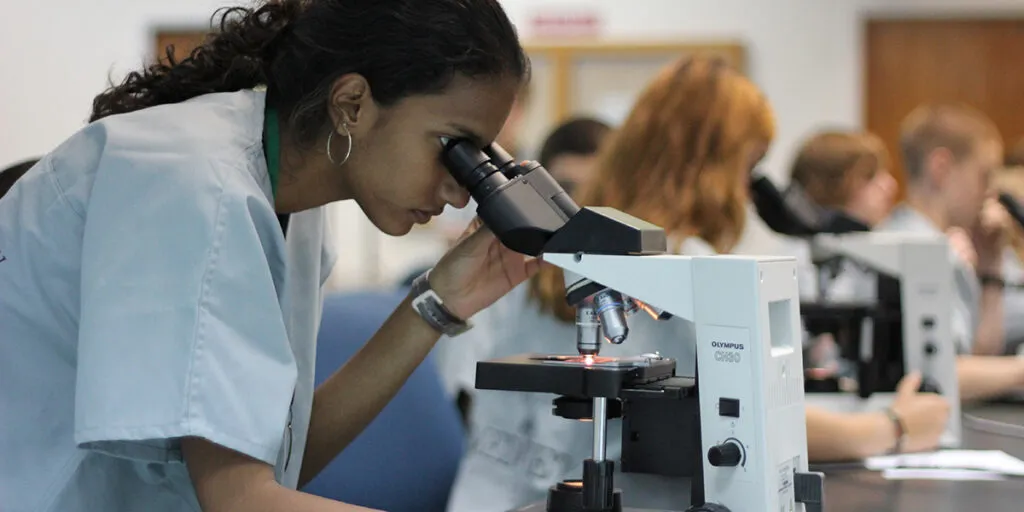 Student studying slides with microscope