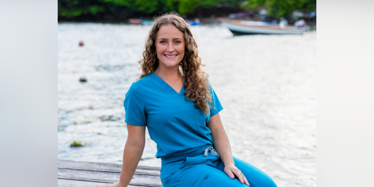 Deanna Boner, SGU SVM student, sits on a dock wearing scrubs News