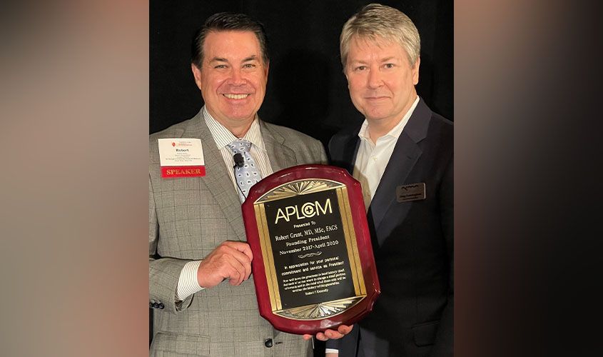 Robert Grant, MD, MSc, FACS, receiving an APLOM Founding President award plaque from a colleague. News