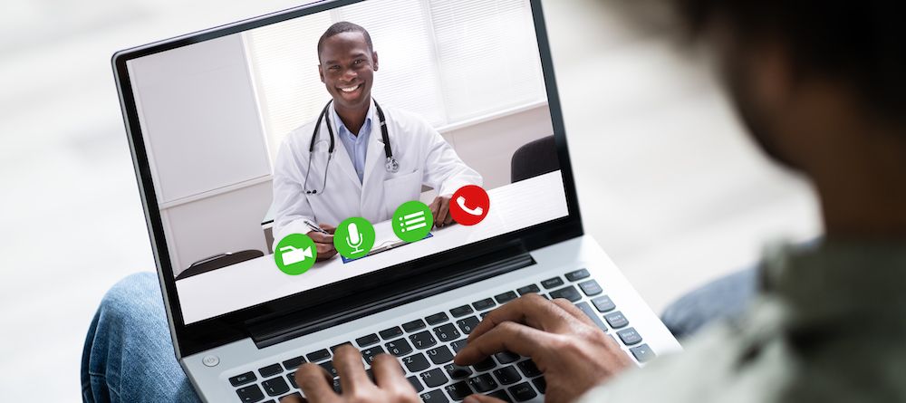 Over the shoulder shot of a patient talking to a doctor using of a digital tablet