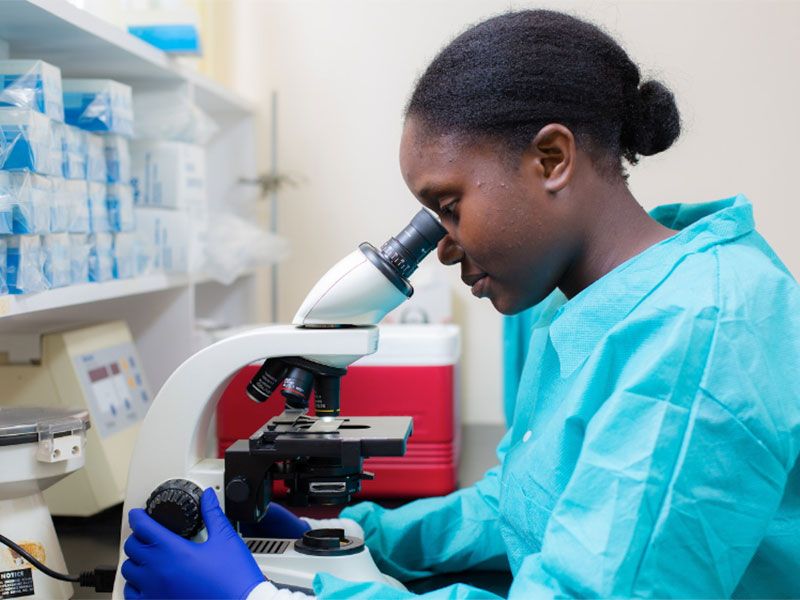 student using microscope